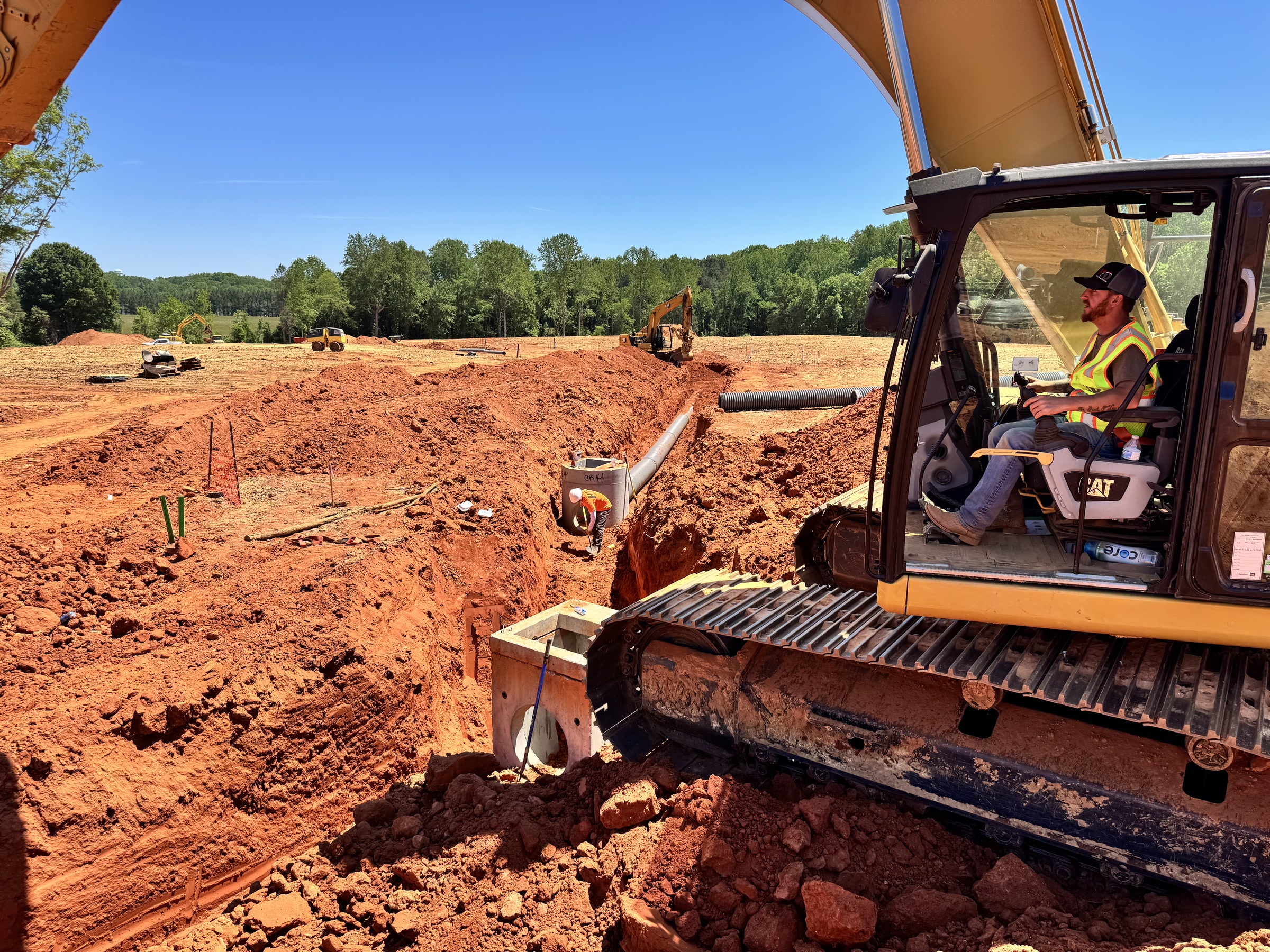 HD Grading operator in the cab of a CAT excavator on a Carolinas job site