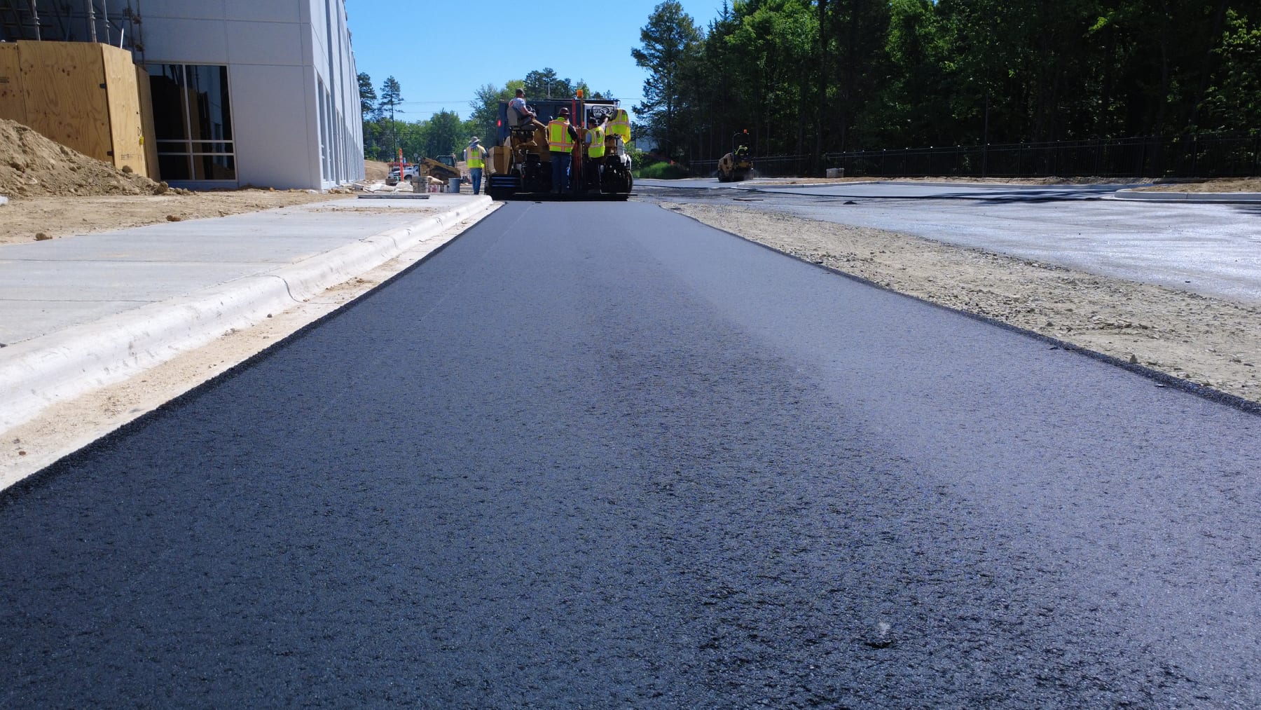 HD Grading paving crew operating an asphalt paver on an active site